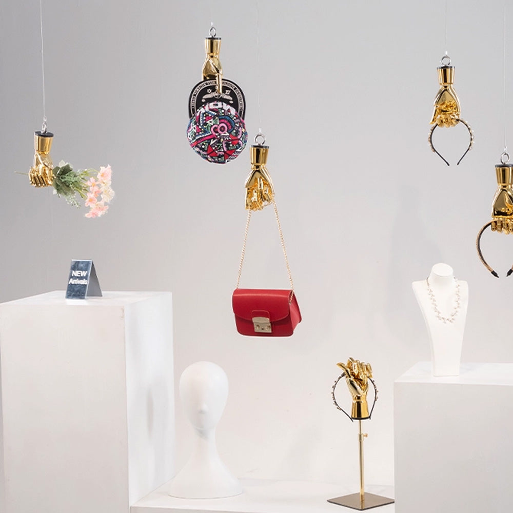 Wall mounted mannequin hand used as a creative accessory holder in a boutique store