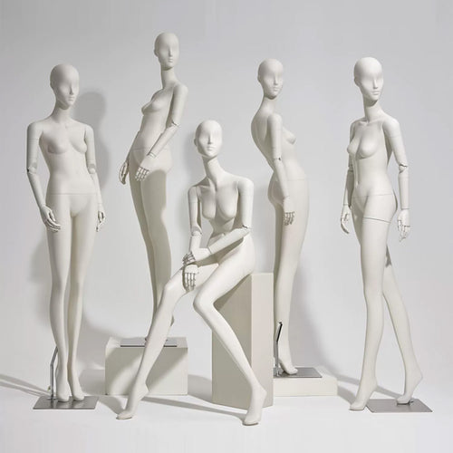 Abstract matte white full body female mannequin with articulated wooden hands for luxury fashion window display.