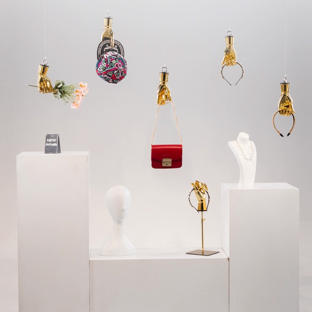 Wall mounted mannequin hand used as a creative accessory holder in a boutique store