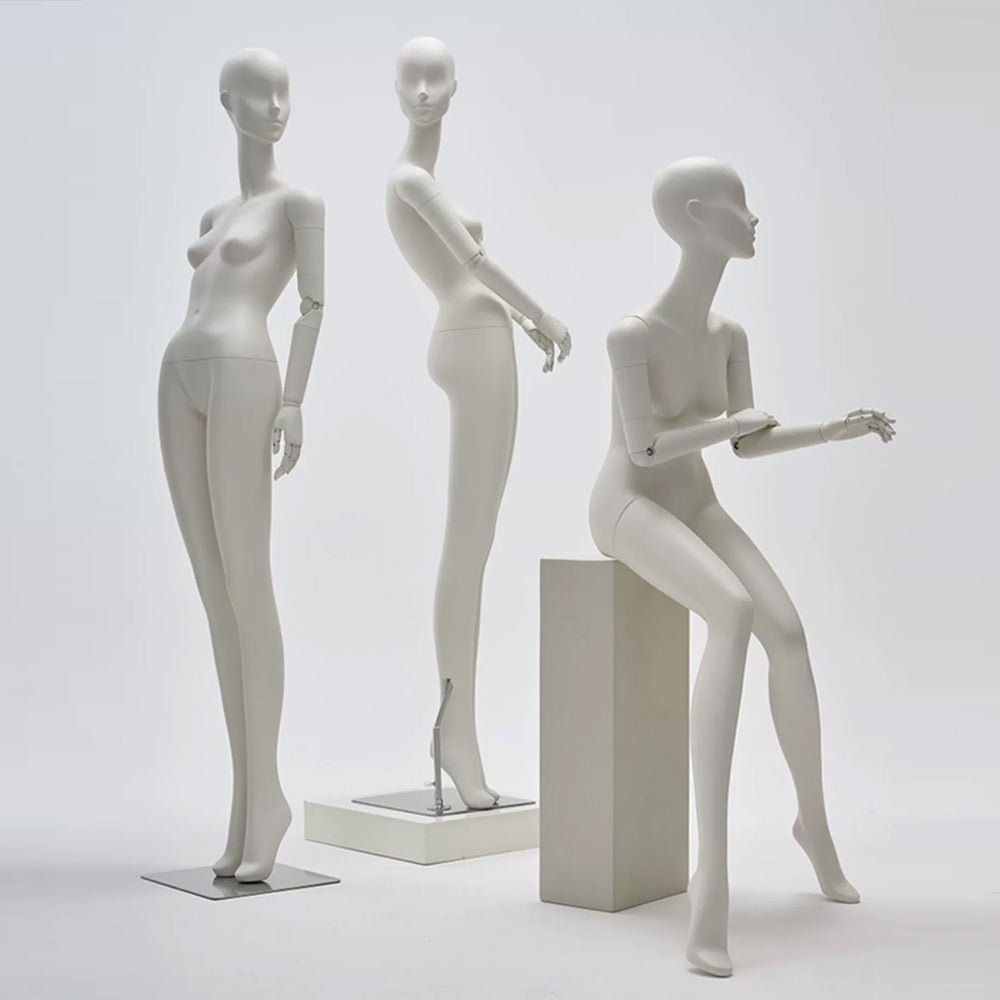 Abstract matte white full body female mannequin with articulated wooden hands for luxury fashion window display.