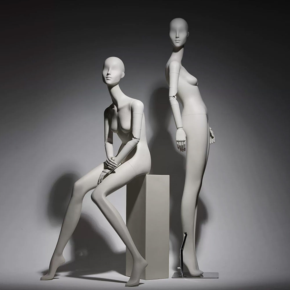 Abstract matte white full body female mannequin with articulated wooden hands for luxury fashion window display.