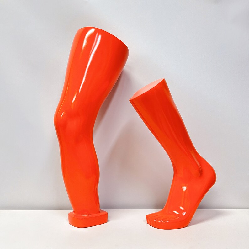 Maniquíes de fibra de vidrio naranja para exhibición: formas de mano, brazo, rodilla y pie para venta minorista de ropa deportiva.