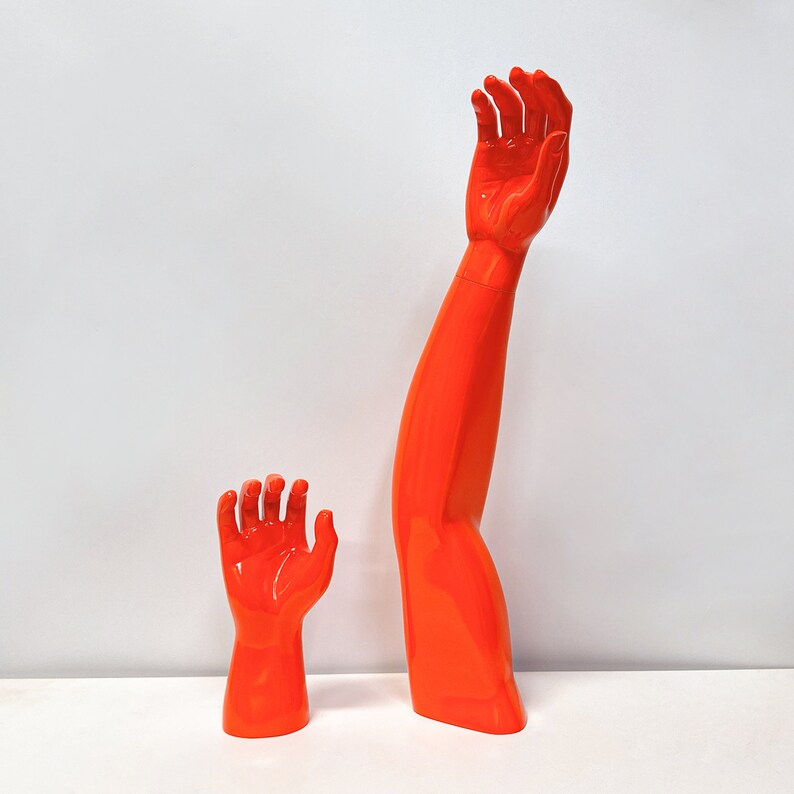 Maniquíes de fibra de vidrio naranja para exhibición: formas de mano, brazo, rodilla y pie para venta minorista de ropa deportiva.