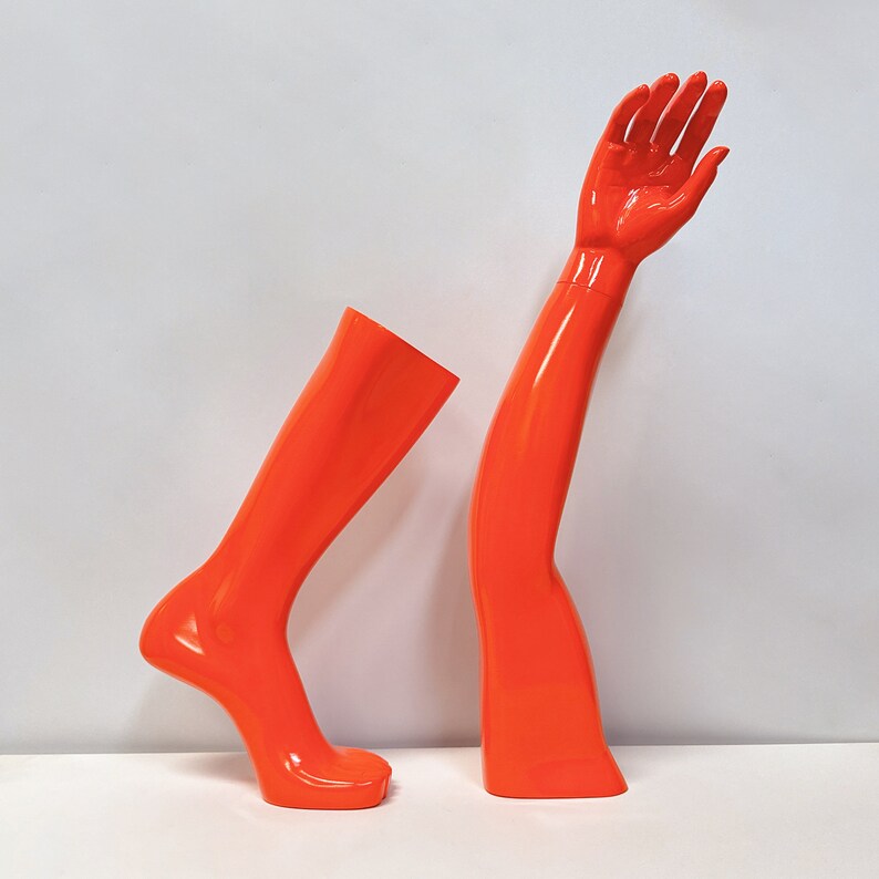 Maniquíes de fibra de vidrio naranja para exhibición: formas de mano, brazo, rodilla y pie para venta minorista de ropa deportiva.