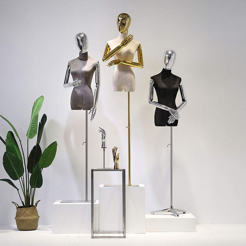 Velvet female mannequin torsos with gold and silver articulated arms arranged for boutique fashion display