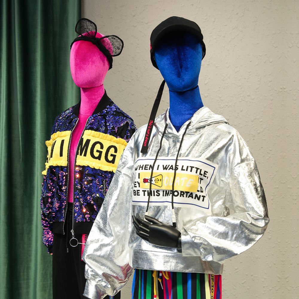 Velvet female half body mannequins displaying dresses suits jewelry and accessories in a retail window